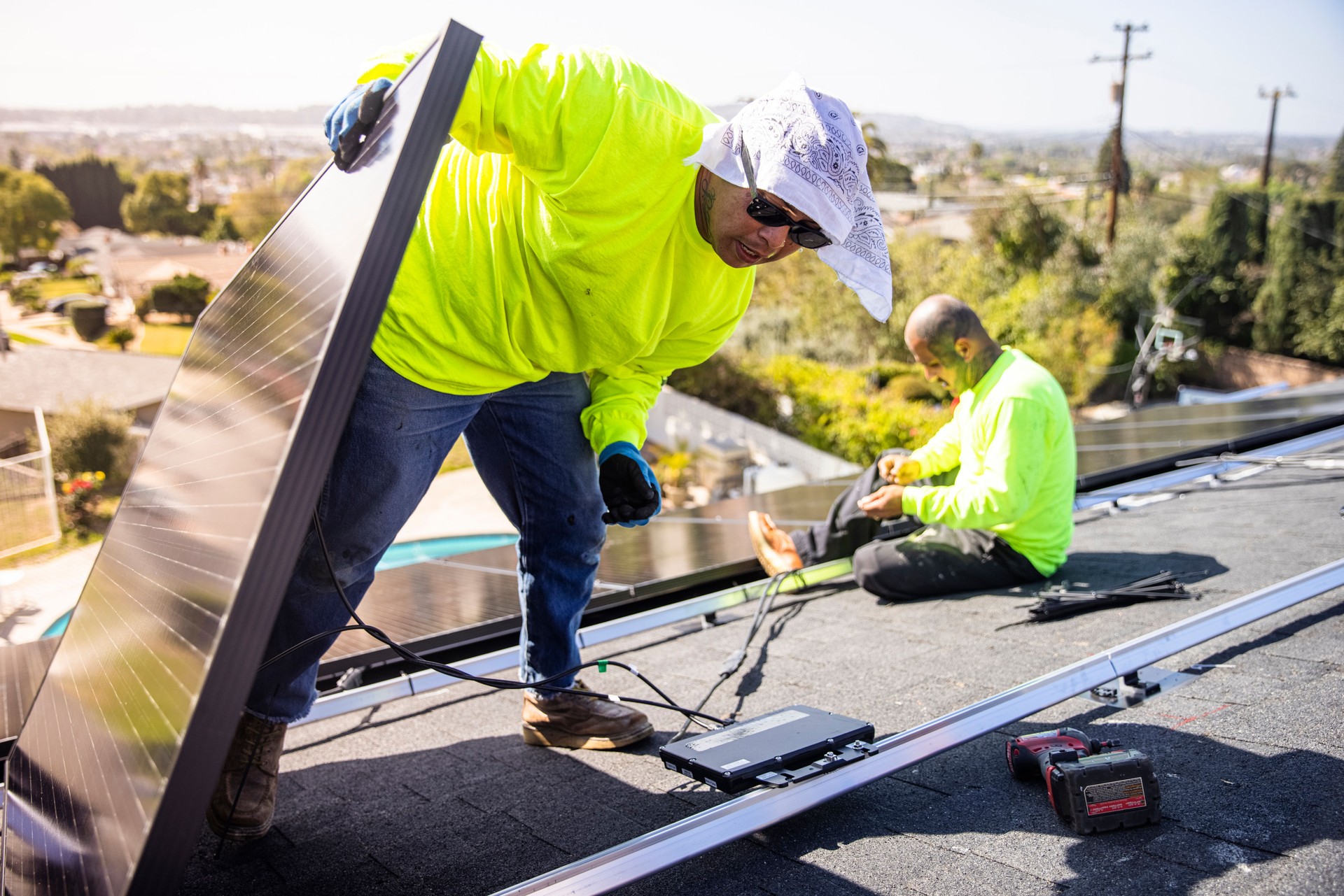 Team of Workers Installing Solar Panels on Residential Rooftop in California